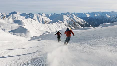 Panorama-skiing-with-two-ski-athletes-in-beautiful-winter-landscape-high-up-in-the-mountains