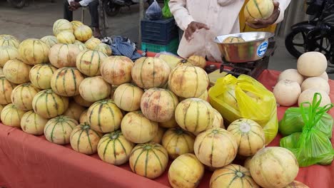 Mann,-Der-Muskmelonfrucht-In-Einer-Schubkarre-Thela-Gaadi-Am-Straßenrand-Von-Indien-Verkauft