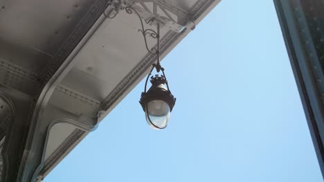 Vintage-Lamp-Hanging-On-The-Roof-Of-Bir-Hakeim-Bridge,-Formerly-The-Bridge-Of-Passy,-In-Paris,-France-At-Daytime