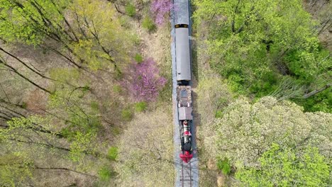 An-Aerial-Down-Angle-View-of-an-1860's-Steam-Passenger-Train-Traveling-Thru-a-Wooded-Area-on-a-Lonely-Single-Rail-Road-Track
