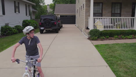 A-boy-on-his-bike-wait-at-the-end-of-his-driveway-to-start-his-ride-as-camera-pulls-back-and-up