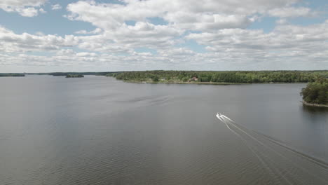 Drone-chasing-speedboat-in-a-Great-Lake,-summer-day,-Sweden,-aerial