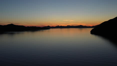 Luftaufnahme-Des-Ruhigen-Ozeans-Bei-Sonnenuntergang,-Schöner-Abendhimmel-Mit-Reflexion-In-Ruhigem-Meerwasser