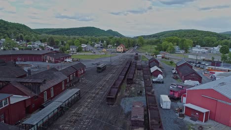 An-Aerial-View-of-an-Abandoned-Narrow-Gauge-Coal-Rail-Road-with-Rusting-Hoppers-and-Freight-Cars-and-Support-Building-Starting-to-be-Restored