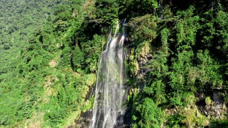 Epic-drone-footage-of-crashing-Wulai-Waterfall-surrounded-by-green-mountain-during-bright-sunny-day-in-national-park-of-Taiwan