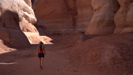 Back-of-Young-Woman-Walking-in-Antelope-Canyon,-Lake-Powell-Arizona-USA,-Natural-Landmark-and-Sightseeing-Location-With-Sandstone-Formations,-Full-Frame-Slow-Motion