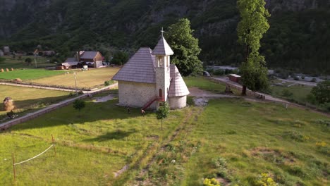 Alpine-Dorfkirche-Auf-Grüner-Wiese,-Umgeben-Von-Hohen-Bergen-In-Theth,-Albanien