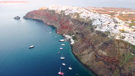 Amazing-video-of-famous-white-and-colourful-picturesque-village-of-Oia-built-on-a-cliff-during-sunset,-Santorini-island,-Cyclades,-Greece