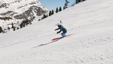 Female-ski-expert-showing-beautiful-ski-turns-on-a-steep-ski-slope-in-beautiful-mountain-panorama