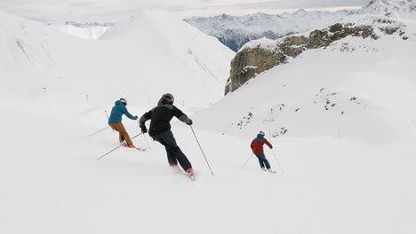 Espectáculo-De-Esquí-Cinematográfico-En-Buena-Formación-De-Tres-Atletas-De-Esquí-En-Una-Estación-De-Esquí-En-Suiza-En-Una-Pista-De-Esquí-Con-Gran-Vista-Panorámica-De-La-Montaña