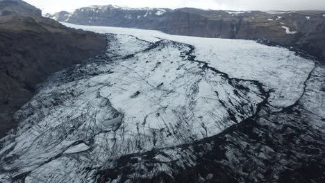 Sólheimajökull-glacier-in-Iceland,-Ice-mass-floe-in-between-mountain-range