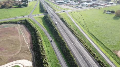 Drone-Raise-shot,-flying-over-farmland-towards-the-motorway-in-Cambridge,-New-Zealand