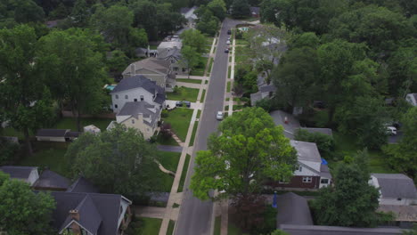 Aerial-descent-from-high-above-a-nice-suburban-neighborhood-down-to-sidewalk-and-green-grass