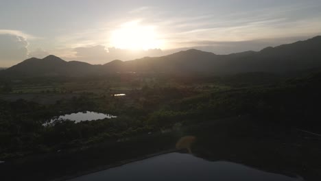 4K-Aerial-Footage-Flying-Toward-Sunset-over-Mountains-near-Khlong-Bod-Reservoir-in-Nakhon-Nayok,-Thailand