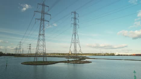 View-Across-Eling-Great-Marsh-With-High-Voltage-Transmission-Towers-In-Southampton,-England,-UK---aerial-drone-shot
