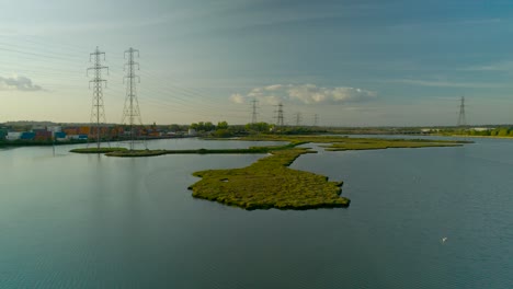 Pull-out-low-level-shot-with-rise-of-high-voltage-transmission-towers-along-Southampton-Wetlands
