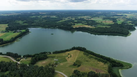 Majestic-lake-and-forest-flatlands-of-Lithuania,-aerial-rotate-view