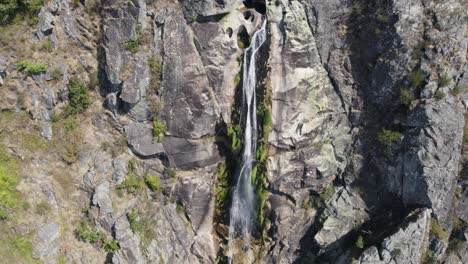 Aerial-High-stream-water-flowing-down-stone-walls,-Serra-da-Freita-Geopark