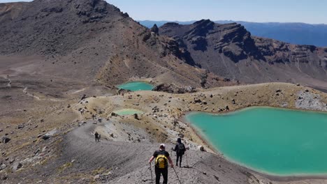 Tourists-hike-down-loose-volcanic-pumice-trail-toward-Emerald-Lakes