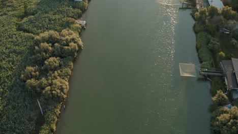 Aerial-view-of-the-fishing-huts-in-the-river-that-flows-into-the-Adriatic-sea,-Lido-di-Dante,-Fiumi-Uniti,-Ravenna-near-Comacchio-valley