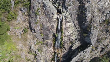 Small-waterfall-falling-on-rocky-cliff