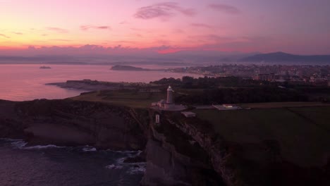 Santander-Spain-aerial-view-of-the-city-during-epic-sunset,-drone-fly-over-lighthouse