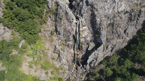 Frecha-Mizarela-cascade-in-Portugal,-aerial-ascending-flyback-view