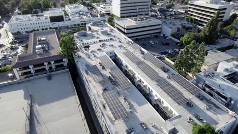 Aerial-green-alternative-solar-panel-technology-on-residential-apartment-building-in-city,-drone-shot