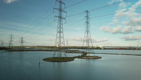 Smooth-low-angle-view-of-high-voltage-electricity-pylons-also-known-as-transmission-towers-near-Southampton-in-the-UK
