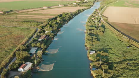 Luftaufnahme-Von-Fischerhütten-Im-Fluss,-Lido-Di-Dante,-Flüsse-Vereint,-Ravenna-In-Der-Nähe-Des-Comacchio-Tals