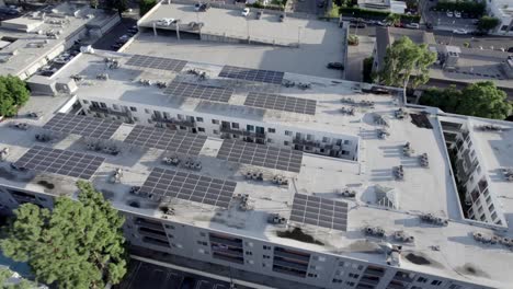 Sherman-Oaks-Encore-apartments-building,-aerial-descending-over-solar-panels-on-roof