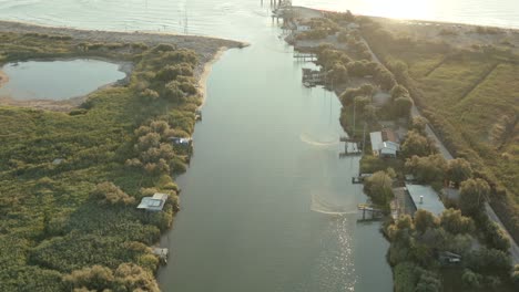 Aerial-shot-of-the-fishing-huts-in-the-river-that-flows-into-the-Adriatic-sea,-Lido-di-Dante,-Fiumi-Uniti,-Ravenna-near-Comacchio-valley