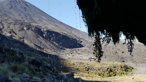 Diagonal-tilt-pan-to-Ngauruhoe-volcano-from-behind-Soda-Spring-Falls