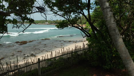 Idyllic-Tropical-Beach-On-A-Private-Resort-In-Sri-Lanka---drone-pullback