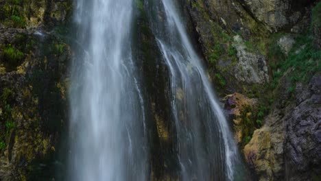 Wasserfall-In-Einer-Massiven-Felsschlucht,-Regentropfen,-Die-über-Klippen-Fallen-Und-Regenbogenfarben-Erzeugen
