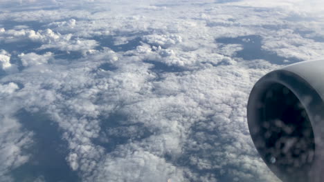 An-amazing-view-of-white-clouds-extending-to-the-horizon-shot-through-the-window-of-an-airplane,-airplane-turbine