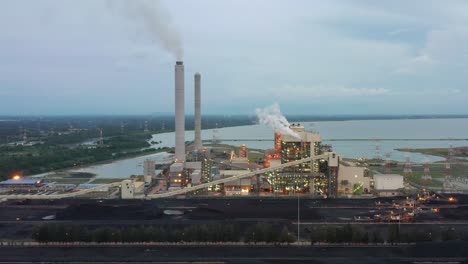 Fly-around-coalfield-and-industrial-ultra-supercritical-coal-fired-power-plant-with-smokes-raising-from-chimney-located-at-lekir-bulk-terminal-jalan,-teluk-rubiah,-manjung,-malaysia