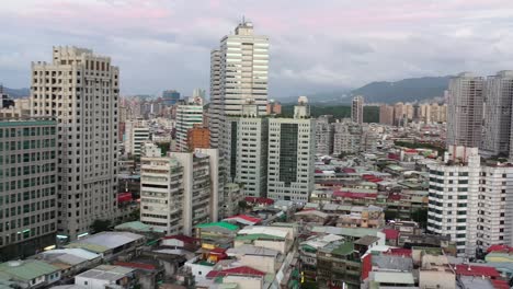 Aerial-establishing-shot,-drone-fly-around-Yongchun-neighborhood-capturing-low-rise-residential-buildings-and-high-rise-skyscrapers-in-downtown-Xinyi-district,-capital-city-Taipei,-Taiwan