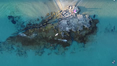 Drohnenclip,-Der-Sich-über-Einer-Felsformation-Am-Rande-Eines-Tropischen-Strandes-In-Calpe,-Spanien,-Nach-Oben-Bewegt