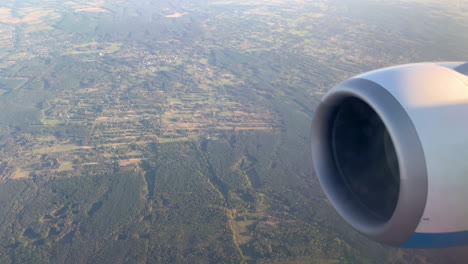 Luftaufnahme-Des-Turbinentriebwerks-Und-Der-Landschaft-Hinter-Dem-Flugzeugfenster