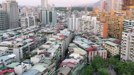 Aerial-slow-dolly-in-tilt-shot-capturing-a-mix-of-old-residential-buildings-and-properties-in-early-development-and-modern-new-skyscrapers-at-Yongchun,-Xinyi-district,-capital-city-Taipei,-Taiwan