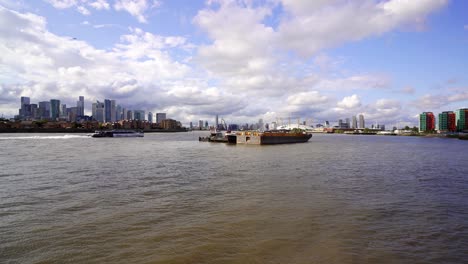 East-London,-wide-view-of-the-river-Thames-looking-toward-the-modern-skyline-of-Docklands-and-Canary-Wharf-with-Greenwich-and-the-Milleniem-Dome-on-the-other-side-of-the-river