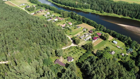Private-homesteads-built-on-Nemunas-river-bank,-aerial-drone-view
