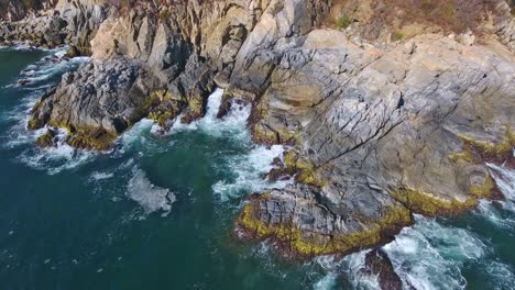 Schwebende-Wellen,-Die-Auf-Interessante-Felsformationen-An-Der-Küste-Krachen