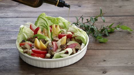 Gießen-Von-Olivenöl-In-Eine-Glasschüssel-Mit-Köstlichem-Frischem-Salat
