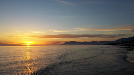 Schöne-Aussicht-Auf-Den-Strand-Von-Marbella-Bei-Sonnenuntergang,-Der-Sich-Vorwärts-über-Das-Wasser-Bewegt,-Luxusurlaubsziel
