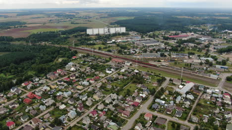 Private-house-district-near-railway-tracks-and-industrial-buildings-in-Jonava-city,-aerial-view