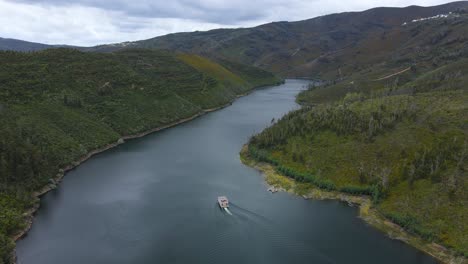 Aerial-view-of-a-Solar-Boat-sailing-through-the-valleys-os-Zêzere-river-in-Portugal-on-a-cloudy-day