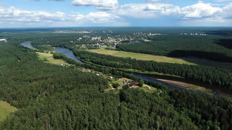 Forestry-landscape-and-city-of-Druskininkai-in-horizon,-high-angle-drone-view