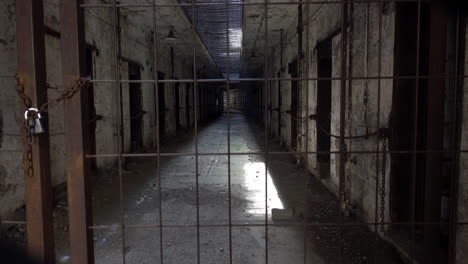Altersschwacher-Gefängniszellenblock,-Der-Durch-Ein-Mit-Vorhängeschlössern-Versehenes-Tor-Gesehen-Wird